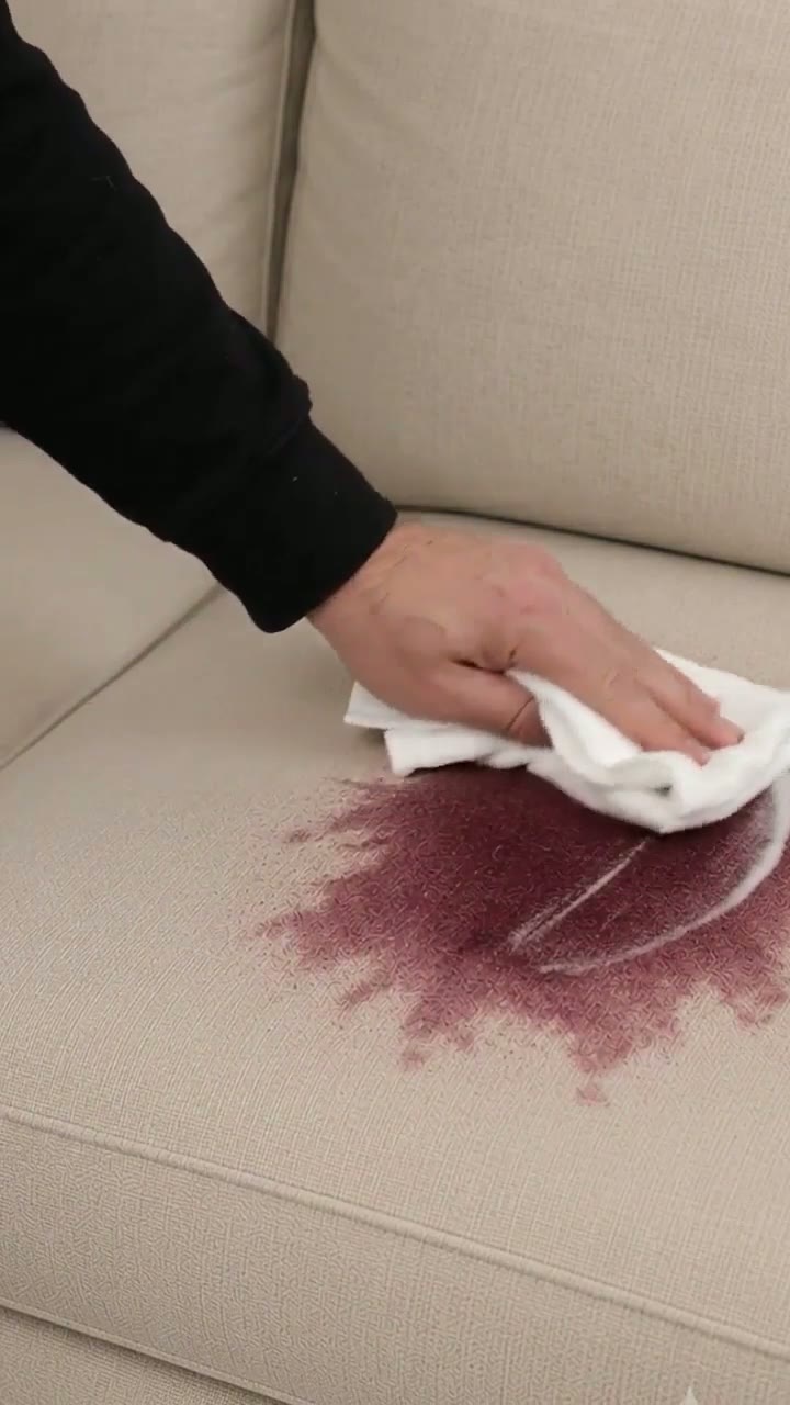 Stain investigation scene on a cream sofa — crime-scene hook frame